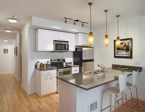 A modern kitchen with a large island and stainless steel appliances.
