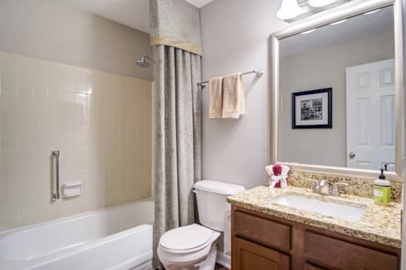 A bathroom with a white tub, toilet, and sink.