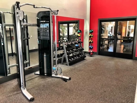 A gym with a red wall and a variety of equipment.