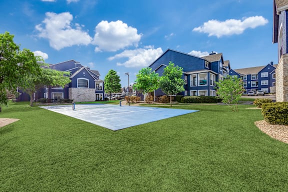 A large grassy area in front of a row of houses.