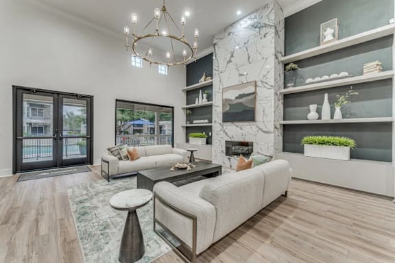 A modern living room with a large sofa, a coffee table, and a chandelier.