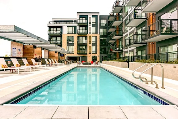 A large swimming pool in front of apartment buildings.