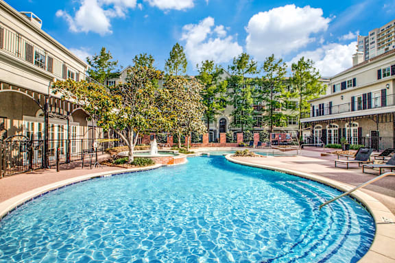 A large swimming pool in the middle of a resort area.