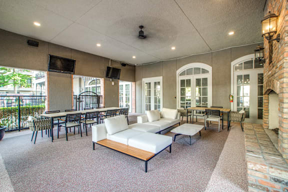 A spacious room with a white couch and a television.
