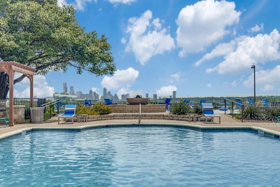 A swimming pool with a view of the city skyline in the distance.