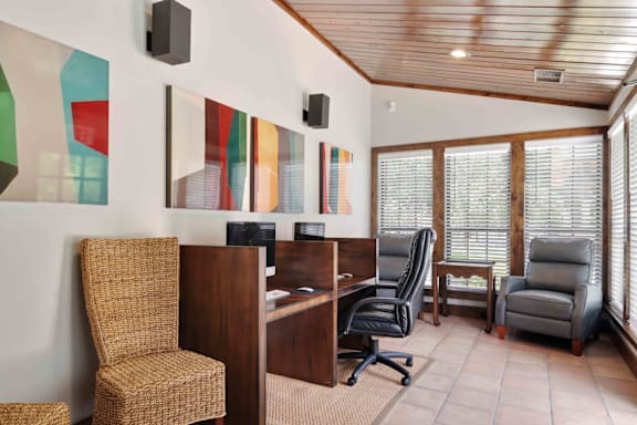 A room with a wooden desk and a black chair.