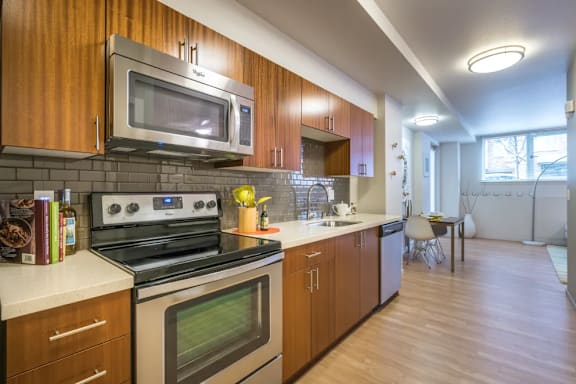 A modern kitchen with wooden cabinets and a stainless steel oven.