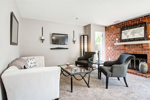 A living room with a fireplace and a white couch.