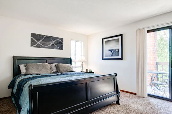 A bedroom with a large bed and a painting on the wall.