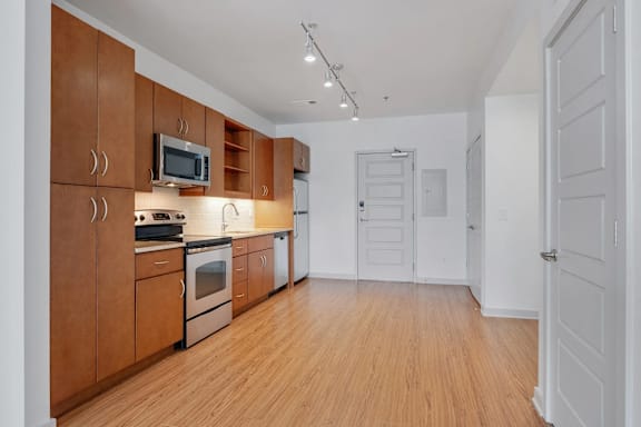 A kitchen with wooden cabinets and a microwave above the stove.
