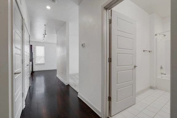 A white door is open to a bathroom.