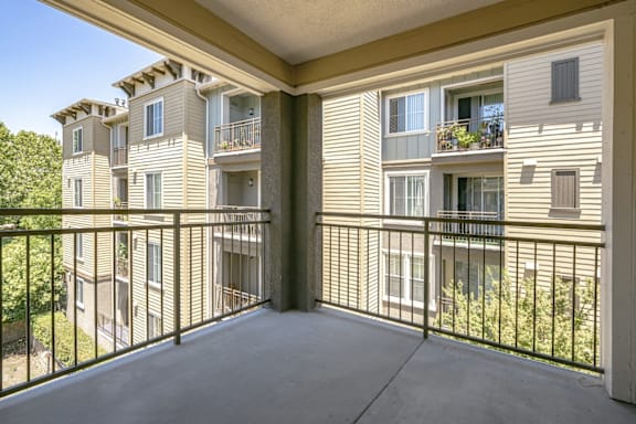 A balcony with a metal railing and a view of a building.