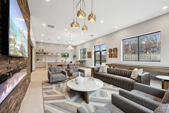 A modern living room with a fireplace and a large screen on the wall.
