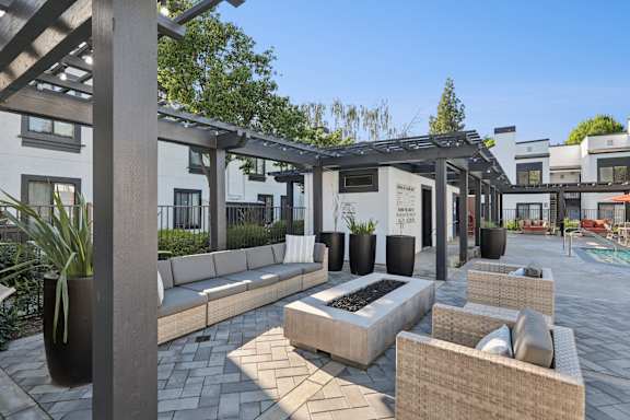 A patio area with a fire pit and seating.
