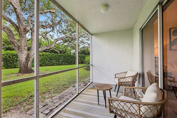 A patio with a table and chairs overlooking a garden.