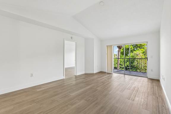 A room with wooden flooring and white walls.