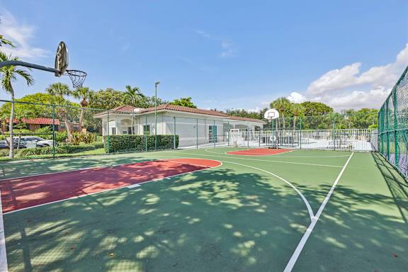 A basketball court with a red and green surface and a basketball hoop.