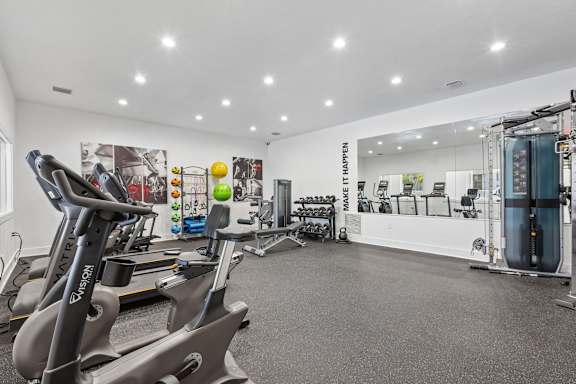 A gym with a row of treadmills and a row of exercise bikes.