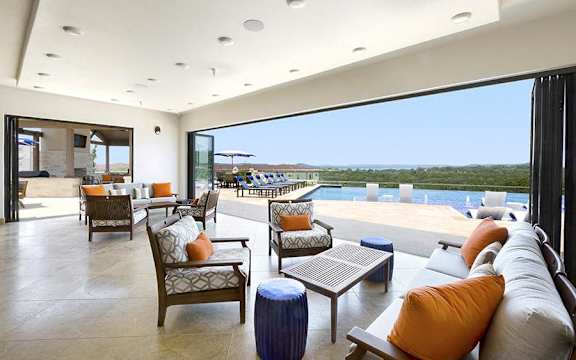 A large room with a pool and a view of the ocean.