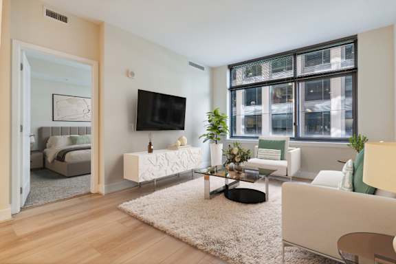 a living room with white furniture and a large window