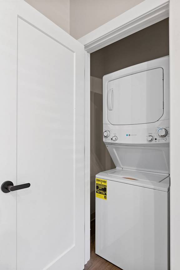 A white dryer is in a white closet.