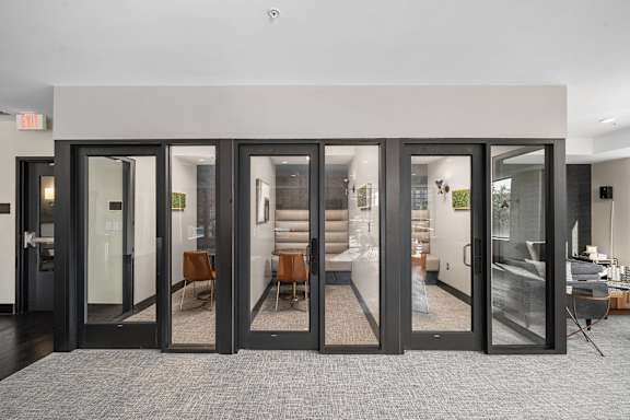 A room with a grey carpet and a glass door.