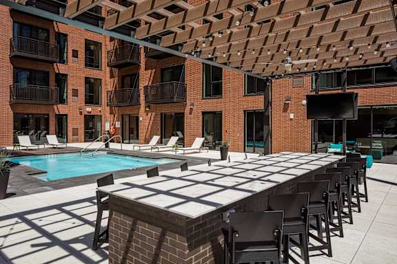 A pool table is surrounded by chairs in a courtyard.