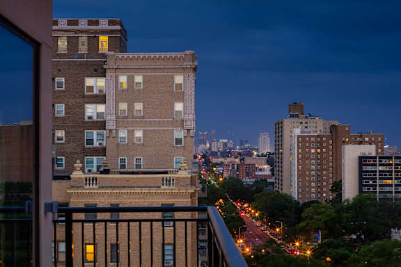 A cityscape at dusk with a view of a highway and buildings.