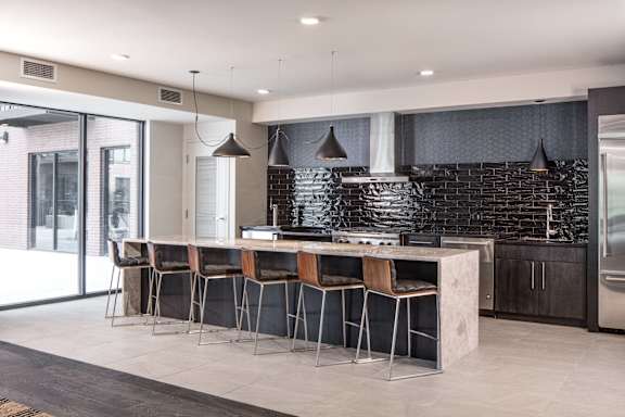 A modern kitchen with a bar area and chairs.
