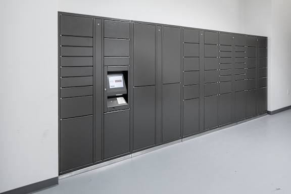 A row of black lockers with a computer on the left one.