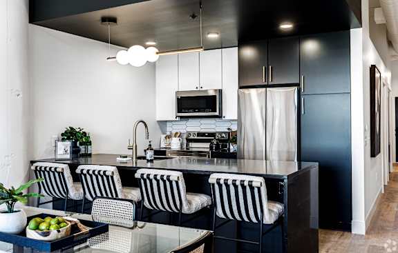 A modern kitchen with black and white striped chairs.