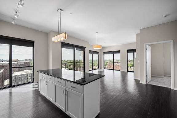 A modern kitchen with a large island and a view of the city.
