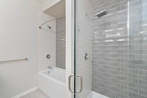 A white bathroom with a glass shower door.