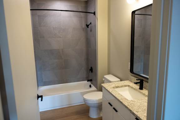 A bathroom with a toilet, sink, and shower.