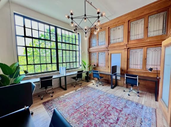 A room with a large rug and a chandelier.