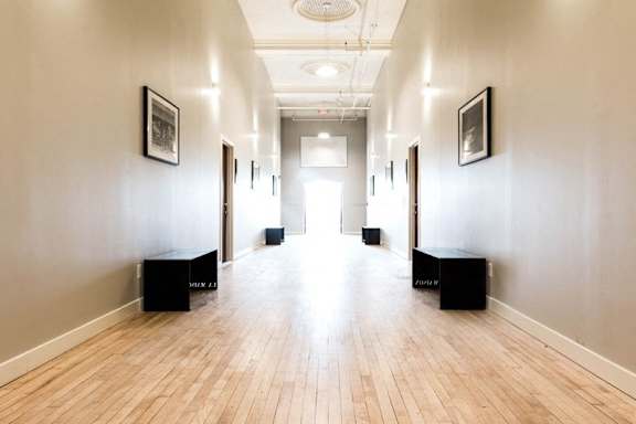 A long hallway with wooden floors and white walls.