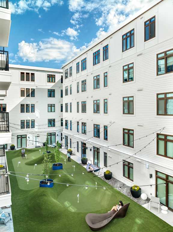 A white building with a green lawn in front.