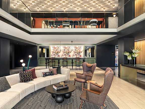 A modern living room with a white sofa, a coffee table, and a large window.