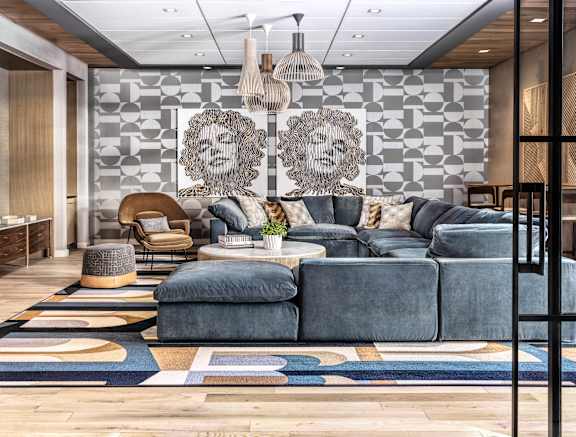 A modern living room with a grey sofa set and a wooden floor.