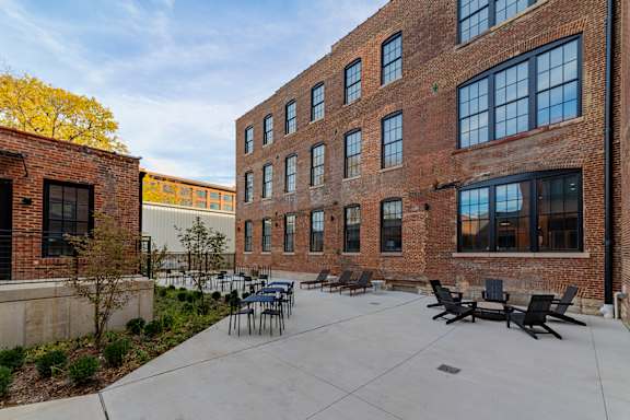 A courtyard with a table and chairs surrounded by brick buildings.