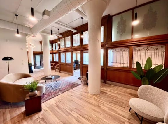 A room with wooden floors and a large window with a view of trees.