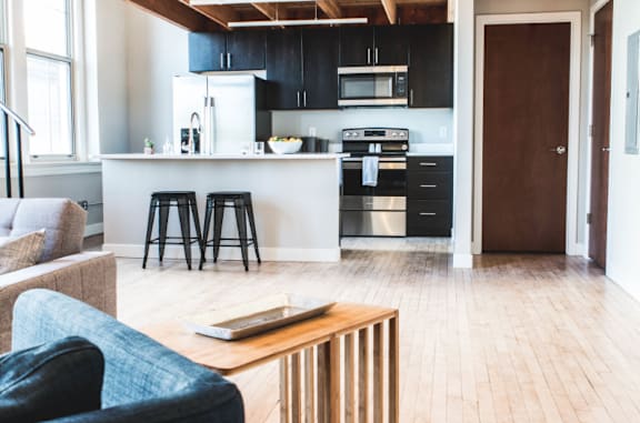 A modern kitchen with a blue chair and a wooden table.