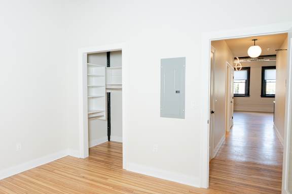 A room with a white wall and a wooden floor.