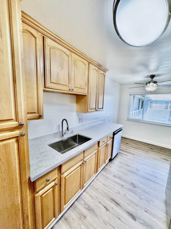 an empty kitchen with wooden cabinets and a sink
