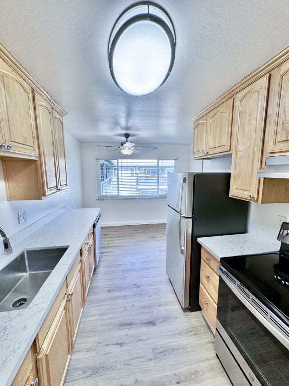 a kitchen with wooden cabinets and a sink and a refrigerator