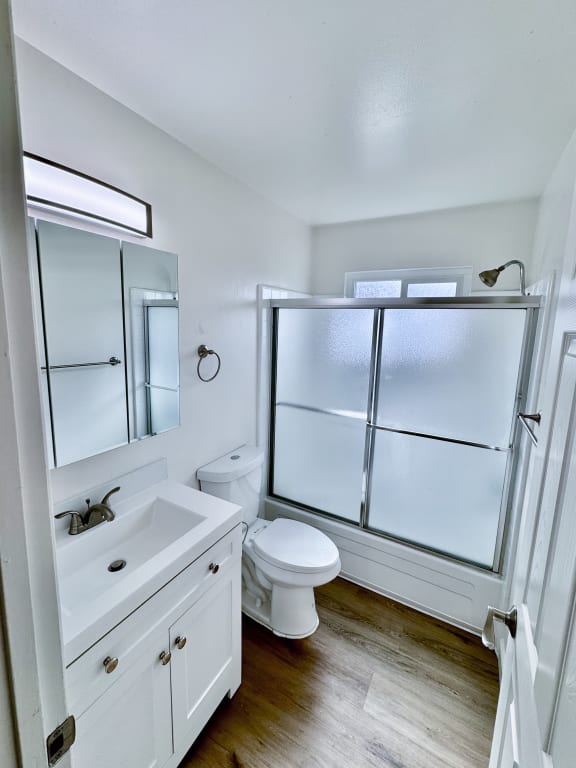 a small bathroom with a shower toilet and sink