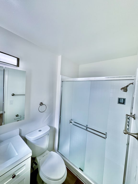 a small bathroom with a shower toilet and sink