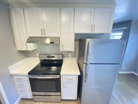 a kitchen with white cabinets and stainless steel appliances
