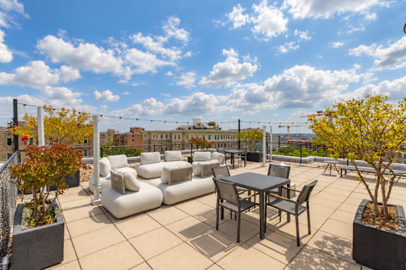 A patio with a table and chairs overlooking a cityscape.