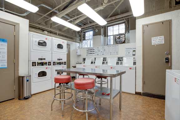 A kitchen area with a table and bar stools.